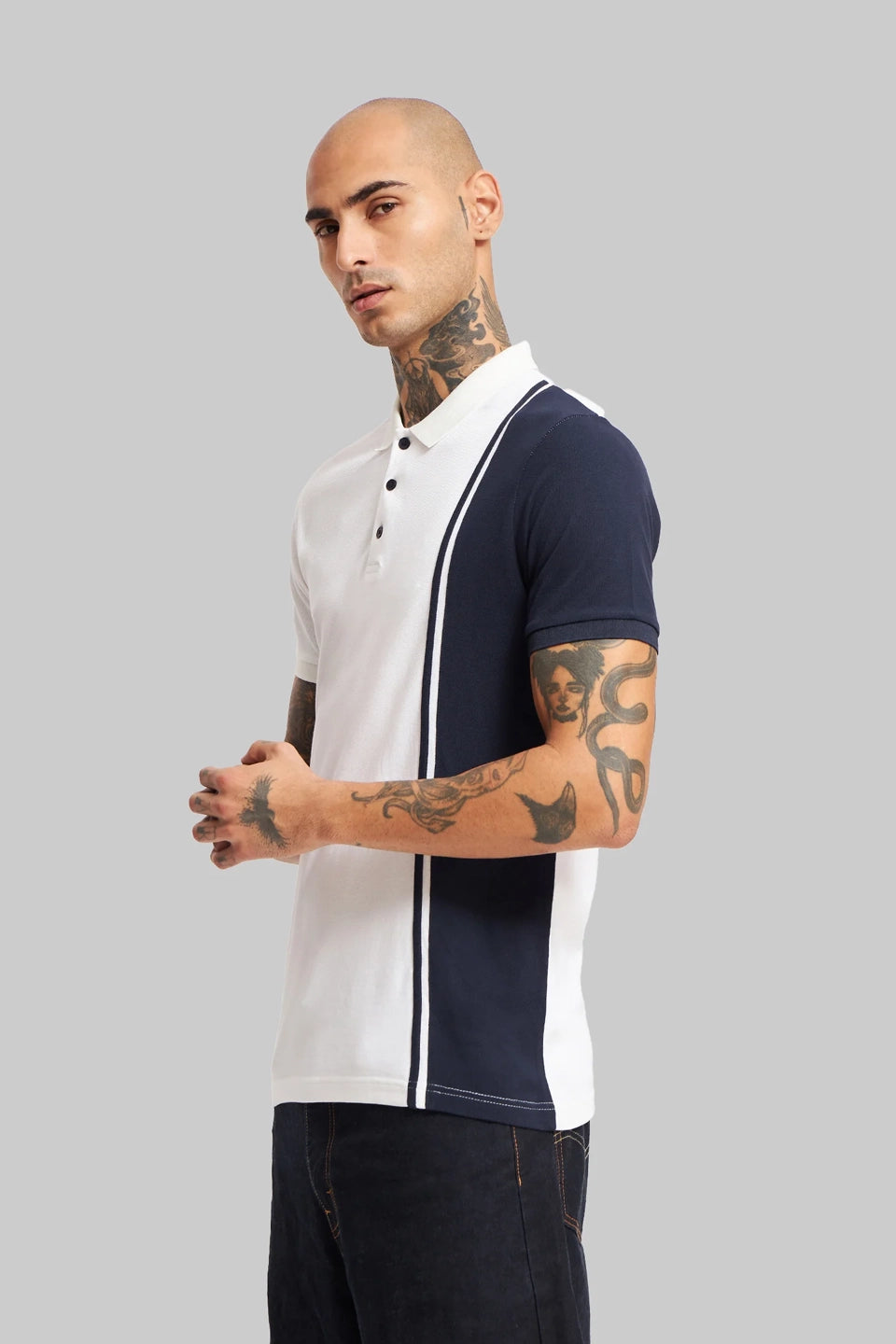Side profile of a man wearing a white polo shirt with a vertical navy blue panel and sleeve detail.
