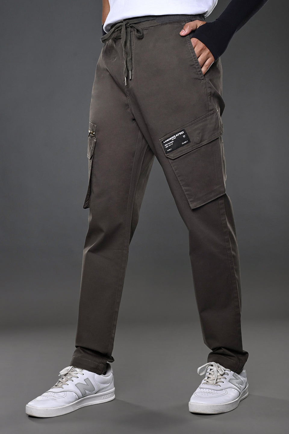 Light grey UNDERRATED CLUB cargo pants, side angle on model in white tee and sneakers