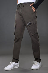 Light grey UNDERRATED CLUB cargo pants, side angle on model in white tee and sneakers