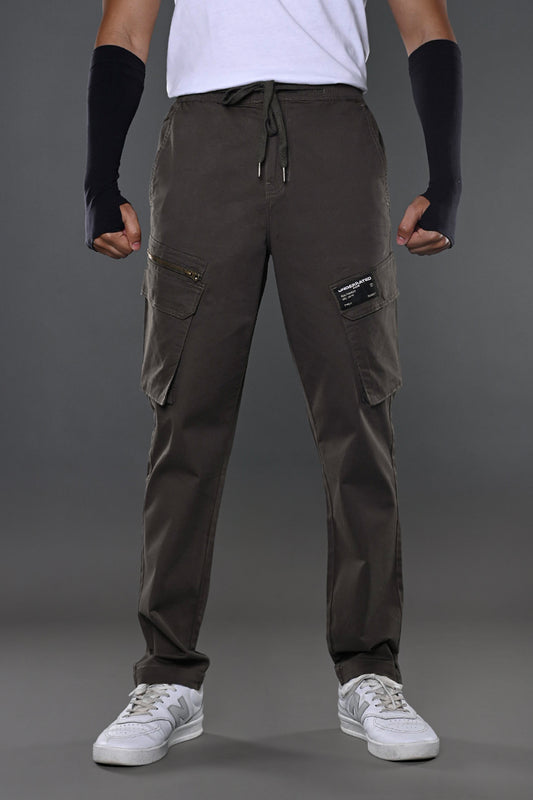 Light grey UNDERRATED CLUB drawstring cargo pants, back view on model with flap pockets and white sneakers.
