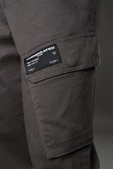 Close-up of charcoal grey UNDERRATED cargo pants thigh pocket with woven label 