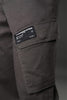 Close-up of charcoal grey UNDERRATED cargo pants thigh pocket with woven label 