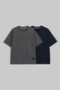 Two short-sleeve crewneck t-shirts displayed side by side on a solid gray background. The front t-shirt is dark gray, and the t-shirt behind it is navy blue.