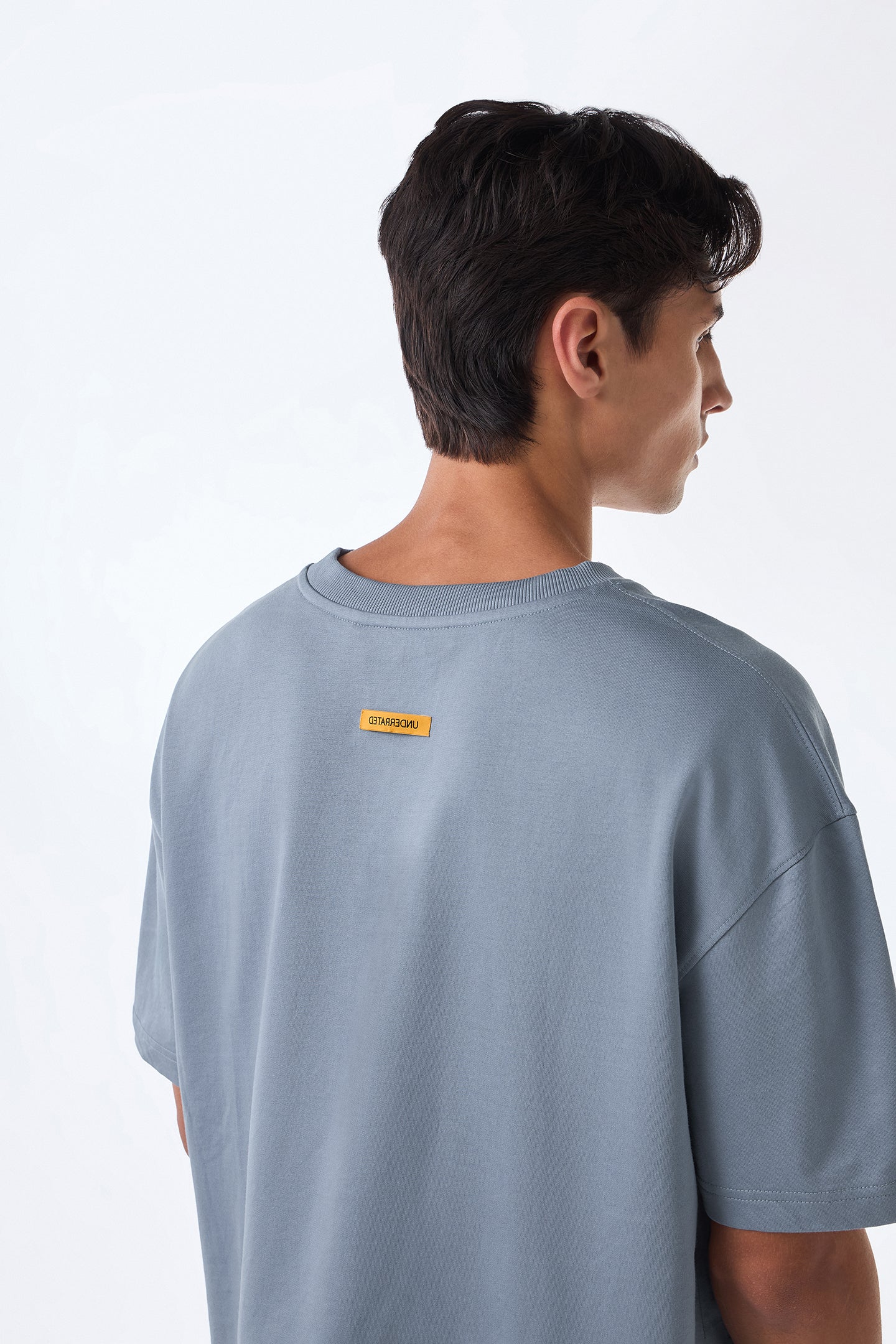 Man left side view, arm extended, minimal studio setting.