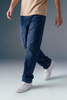 Person wearing blue jeans and white sneakers on a gradient background