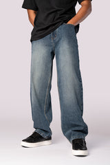 Three-quarter front view of the model in dark wash baggy jeans.