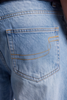 Close-up of the back pocket of light blue denim jeans, showing the classic curved pocket shape and contrast gold/yellow stitching.