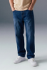 Person wearing blue jeans and white sneakers on a gray background
