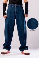 Full-body view of a person wearing baggy, dark blue jeans with the cuffs rolled up, with a circular inset showing a close-up of the fabric's texture.
