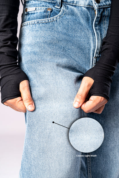 Close-up of the front of light-wash blue jeans, with a circular inset magnifying the 