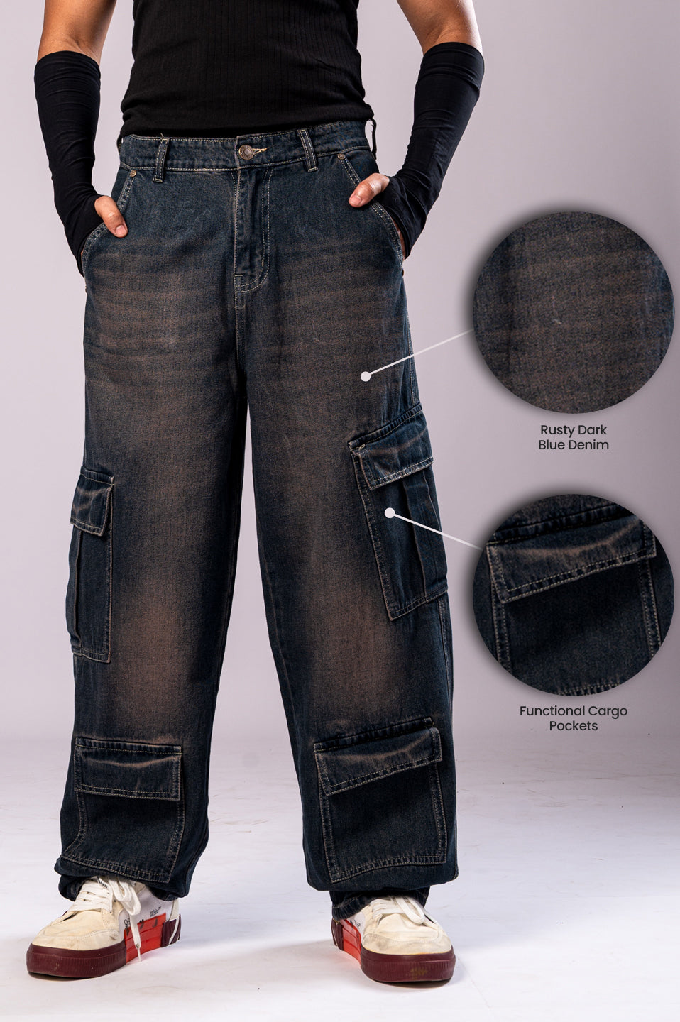 Front view of a person wearing dark, rusty-blue baggy cargo jeans, with two circular insets highlighting the "Rusty Dark Blue Denim" fabric and the "Functional Cargo Pockets."