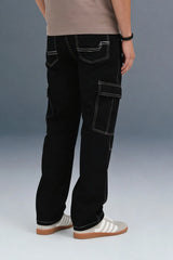 Back view of black cargo jeans showing the white stitching on the rear pockets and side utility pockets.