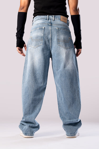 Back view of the light wash baggy jeans on a model, with rolled cuffs.