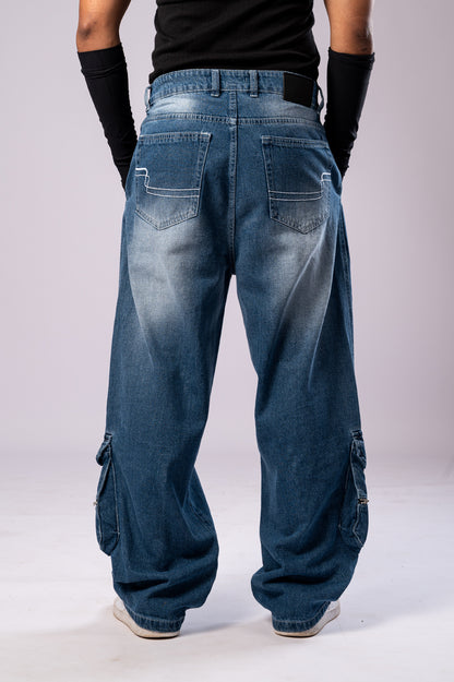 Full-body back view of a person wearing light-wash blue baggy cargo jeans, showing the back pockets and faded details.