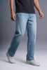 A person wearing light blue straight-leg jeans, a black t-shirt, and white sneakers, shown from the waist down against a gray studio background.