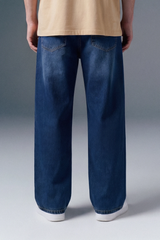 Person wearing blue jeans on a gray background