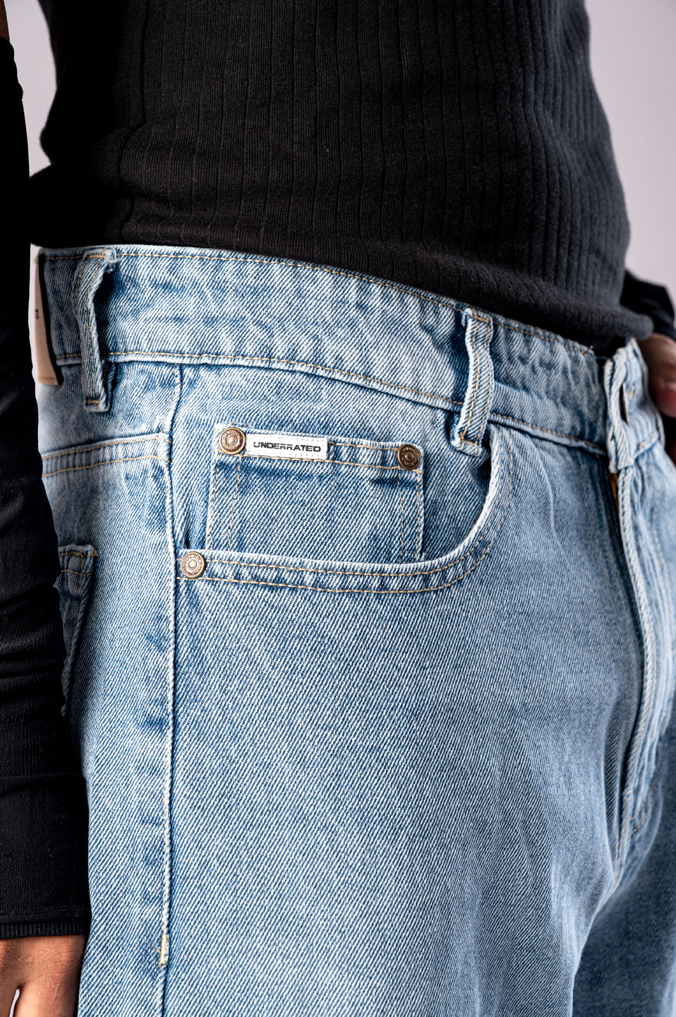 Close-up of the front pocket and waistband detail on Ice Blue Wash baggy denim jeans.