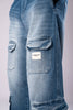 Close-up of the side cargo pocket on light-wash blue jeans, featuring a white Underrated Club logo patch.