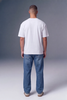 A man viewed from behind wearing a plain white short-sleeve t-shirt and blue jeans, standing against a gray studio background.