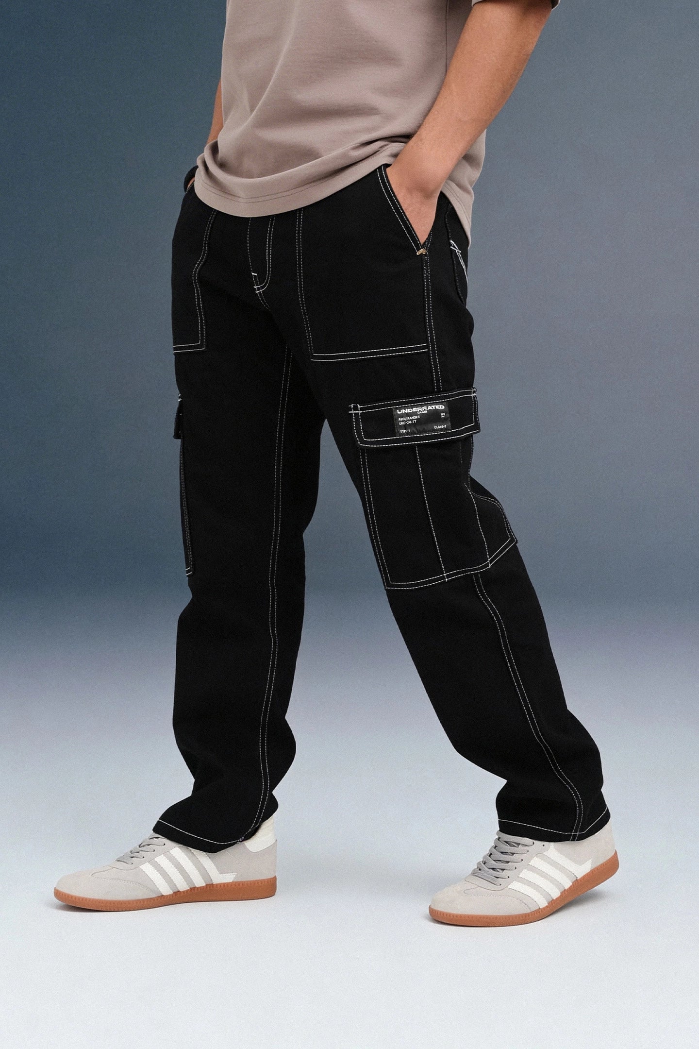 Side view of a person walking in black cargo pants, highlighting the white stitching and utility pockets.