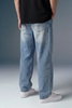 Person wearing light blue jeans and a black shirt against a gray background