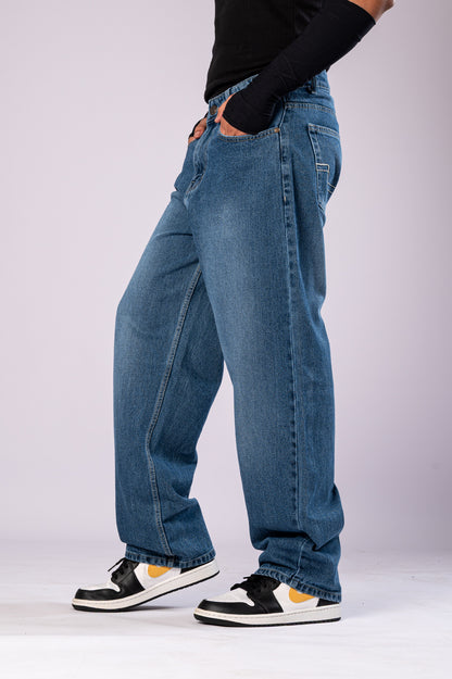 Side profile of the baggy denim jeans, emphasizing the loose, relaxed silhouette.
