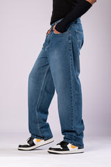 Side profile of the baggy denim jeans, emphasizing the loose, relaxed silhouette.