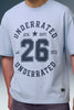 A close-up of a person wearing a light blue t-shirt with a dark navy graphic print on the front that reads 'UNDERRATED ATH. DEPT.