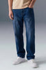 Person wearing blue jeans and white sneakers on a gray background