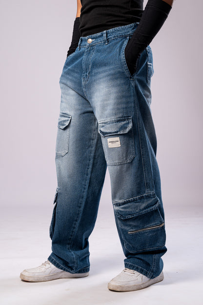 Angled side view of a person wearing light-wash blue baggy cargo jeans, showing the multiple pockets and loose fit.