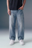 Person wearing blue jeans and white sneakers on a gray background