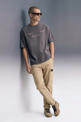 Men's Dark Grey Oversized T-Shirt Full Length — Styled with Beige Pants | Underrated Club
