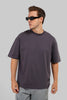 Man wearing a dark gray t-shirt and sunglasses on a light gray background