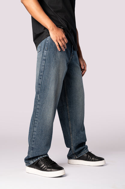 Side profile of the dark wash baggy denim jeans, showing the wide leg.
