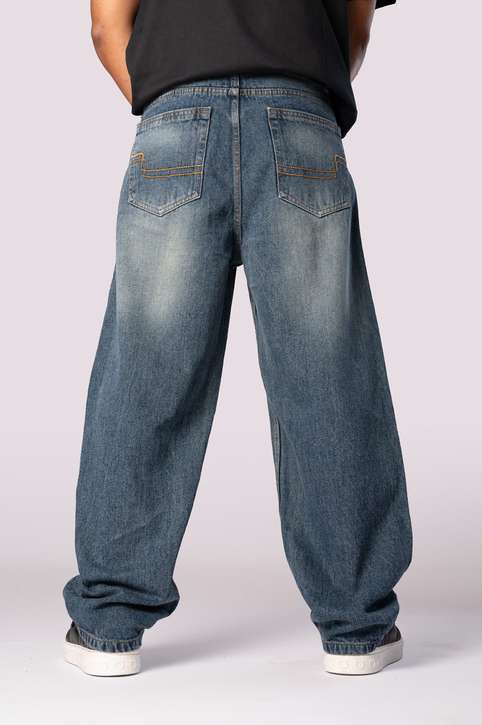 Full-length back view of the dark wash baggy relaxed fit denim jeans.
