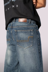 Close-up of the back of the denim jeans, showing the rear pockets and wash detail.