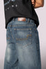 Close-up of the back of the denim jeans, showing the rear pockets and wash detail.