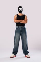 Full-body shot of the model in dark wash baggy jeans with arms crossed.