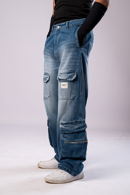 Side view of a person wearing light-wash blue baggy cargo jeans with multiple pockets, a black top, and white sneakers.