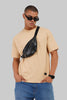 Beige t-shirt model sunglasses crossbody bag side profile jeans casual street style Underrated Club.
