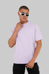 A man in sunglasses wearing a light purple basic t-shirt and black shorts against a grey background.