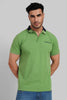 A muscular man wearing a bright lime green polo shirt with a dark collar, looking forward in a studio setting.