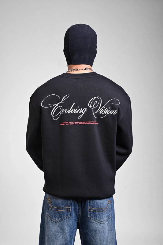 Back view of a black sweatshirt featuring large white cursive "Evolving Vision" text across the shoulders.