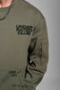 Close-up of olive green men’s sweatshirt featuring Under Rated Club chest print and utility sleeve pocket.