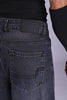 Close-up of dark grey acid-wash denim back pocket and waistband.