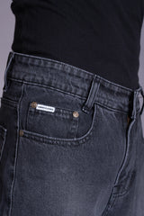 Front view close-up of dark grey acid-wash denim featuring a branded pocket tag.