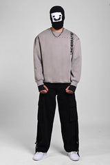 Front view of a person in a grey sweatshirt with vertical shoulder text, a silver chain, and a graphic balaclava.