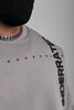 Close-up of a grey sweatshirt with a silver chain and 