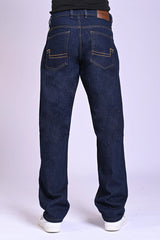 Back view of dark indigo blue jeans featuring a tan leather waist patch and curved pocket stitching.