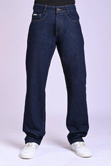 Front view of dark indigo blue relaxed-fit jeans on a person wearing white sneakers.